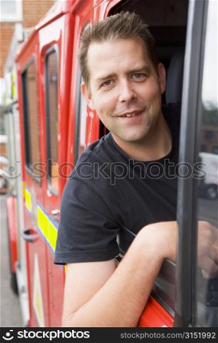 Fireman sitting in fire engine with head out window
