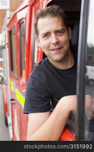 Fireman sitting in fire engine with head out window