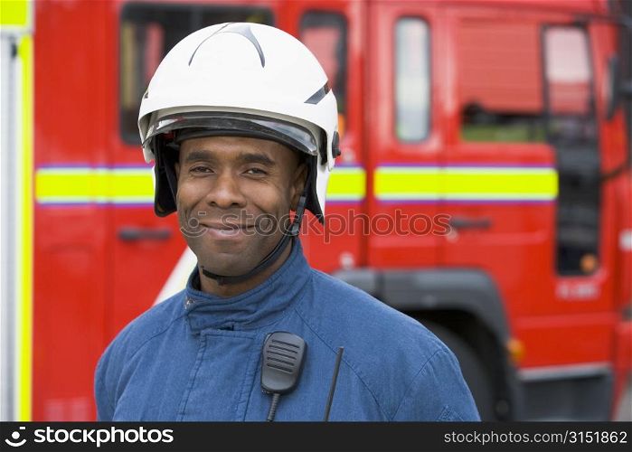 Fireman standing by fire engine wearing helmet
