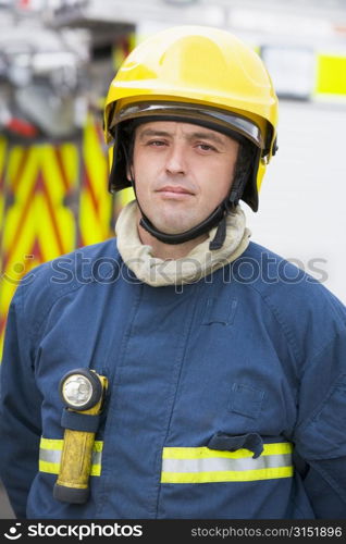 Fireman standing by fire engine wearing helmet