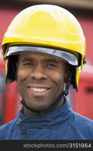 Fireman standing by fire engine wearing helmet