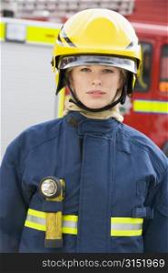 Firewoman standing by fire engine wearing helmet