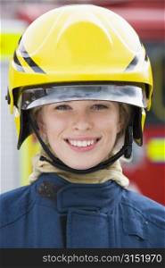 Firewoman standing by fire engine wearing helmet