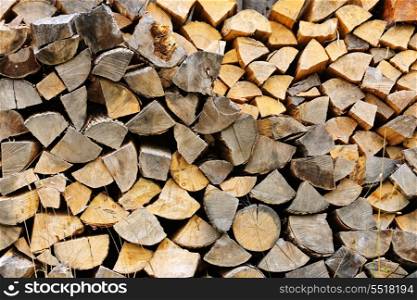 Firewood. Background of chopped and split firewood logs stacked