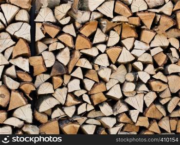 Firewood chopped and folded, prepared for oven natural texture . A stack of chopped firewood stacked on top of each other