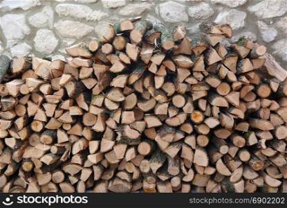 Firewood in a stone wall. Backgrounds and textures