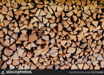 Firewood pile stacked chopped wood trunks for winter heating fireplace