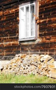 firewood stacked by the window, near a wooden house