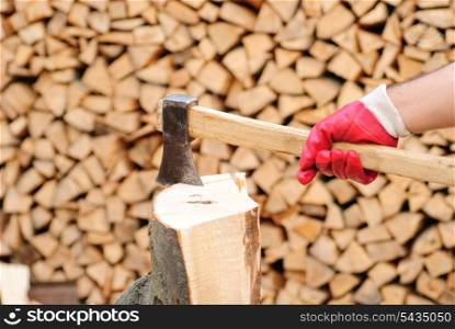 Firewood with axe and male hand. Stocking the fuel.