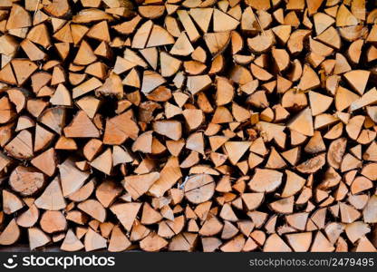 Firewood wooden logs big chopped trunks stacked pile dry for winter fireplace texture background