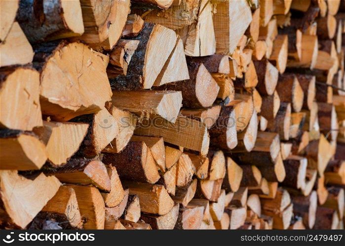 Firewood wooden logs chopped trunks stacked pile dry for winter