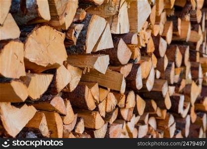 Firewood wooden logs chopped trunks stacked pile dry for winter
