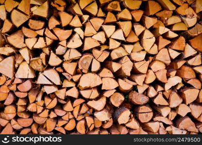Firewood wooden logs chopped trunks stacked pile drying for winter fireplace background