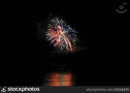 Fireworks And Reflected Colors. Colorful nighttime fireworks against a solid black sky over Lake Tahoe on the fourth of July holiday 2010