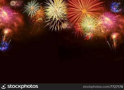 Fireworks colorful explosions on black, festive holiday background with copy space. Fireworks explosions on black