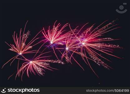Fireworks exploding in violet colors on the dark sky celebrating the new year