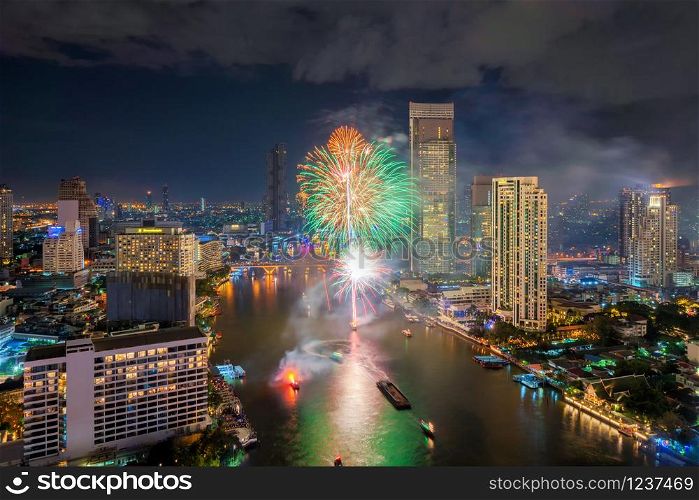 Fireworks with boats at Taksin Bridge with Chao Phraya River on New year day, Bangkok Downtown. Thailand. Financial district, urban city. Skyscraper and high-rise buildings at night.
