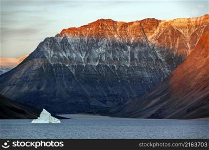 First rays of dawn sunlight on the mountain tops of Blomsterbugten in Kaiser Franz Joseph Fjord on the northeast coast of Greenland.