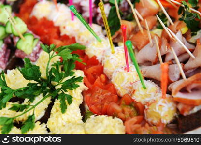 fish and meat snack with vegetables on chopsticks