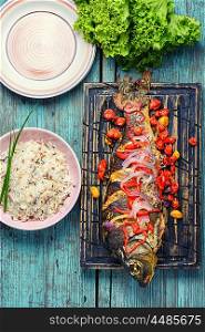 Fish and rice. Baked fish in tomatoes and onions with spices and garnished with rice