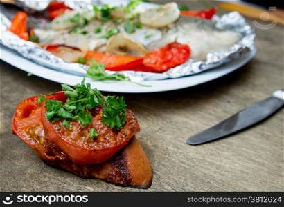 fish baked in foil with peppers, onions and herbs
