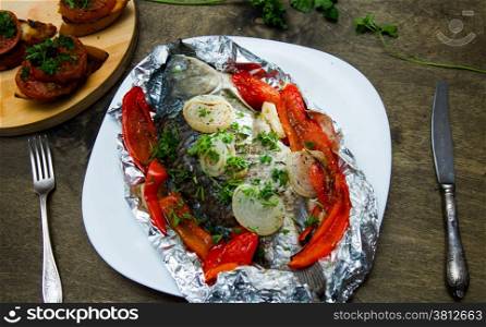fish baked in foil with peppers, onions and herbs