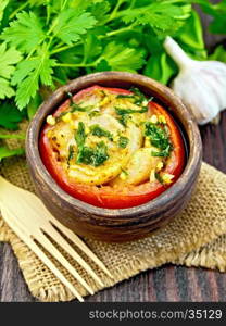 Fish baked in tomato in Zandvoort in clay bowl on a napkin of burlap, parsley on a dark wooden board