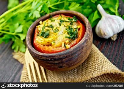 Fish baked in tomato in Zandvoort in clay bowl on a napkin of burlap, parsley on a wooden boards background