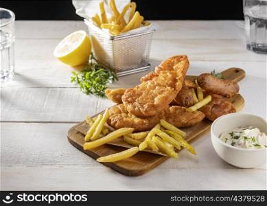 fish chips chopping board with lemon sauce