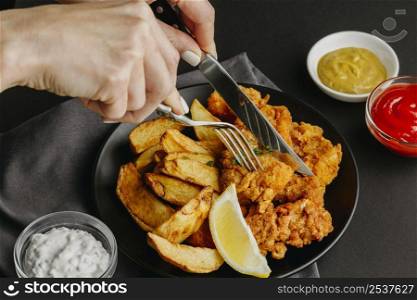 fish chips plate with lemon slice woman with cutlery