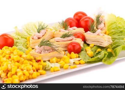 Fish cream in pastries, sweet corn, cherry tomato and lettuce on white plate.