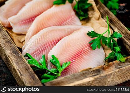 Fish fillet with parsley on a wooden tray. Macro background. High quality photo. Fish fillet with parsley on a wooden tray.