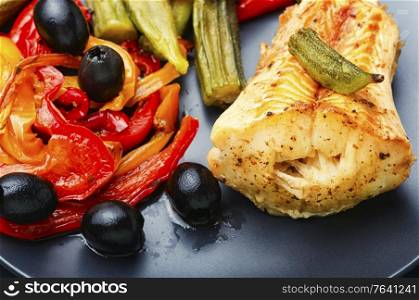 Fish grenadier baked with vegetables on plate.Seafood.Close up. Baked fish with vegetables