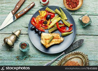 Fish grenadier baked with vegetables.Seafood on wooden background. Baked fish with vegetables