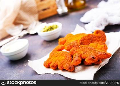 fish nuggets with sauce on a kitchen table