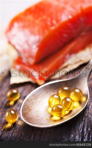 Fish oil capsules with omega 3 on wooden board