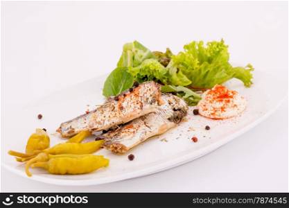 Fish, peppers, lettuce and cream on white plate.