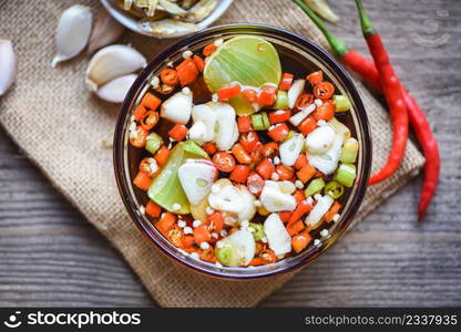 fish sauce on glass bowl and fresh chili garlic lemon lime and small dried fish on sack, fish sauce obtained from fermentation fish or small aquatic animal, fermented foods