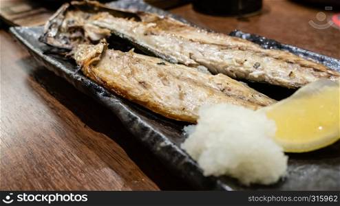 Fish served while grilling on metal dish at Japanese izakaya style restaurant