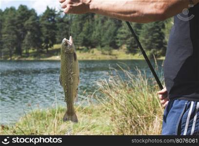 Fisherman caught a fish in mountain dam