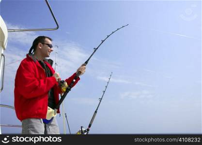 Fisherman fishing on boat big game tuna, blue sunny sky