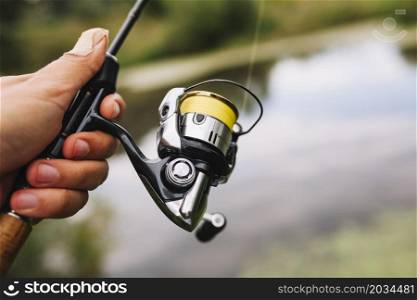 fisherman holding fishing rod blur background