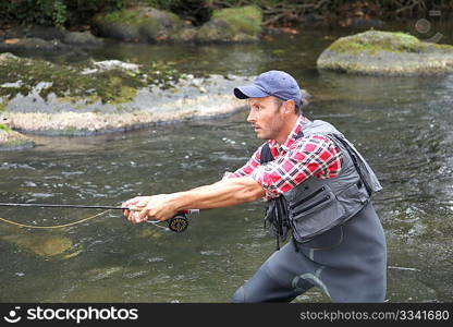 Fisherman in river with fly fishing line