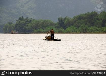 Fisherman on a bamboo raft in a river, XingPing, Yangshuo, Guangxi Province, China