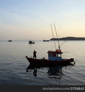 fisherman on fishing boat at sunrise time