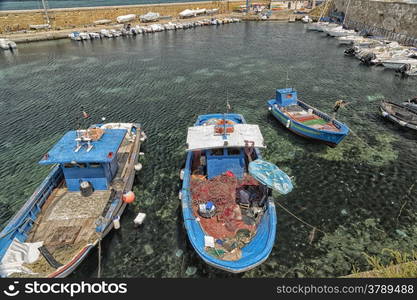 Fisherman repairs his net on boat in harbour in Gallipoli (Le) in Southern Italy