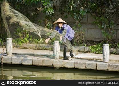 Fisherman throwing a fishing net in a lake, Guilin, Guangxi Province, China