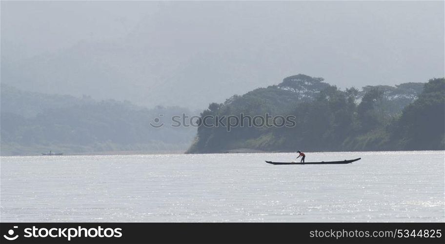 Fisherman with his net on boat in River Mekong, Laos