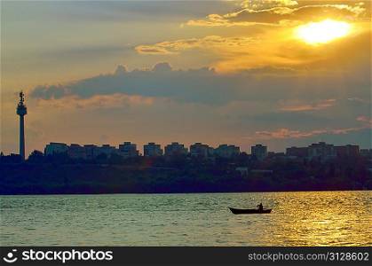 fishermen in boat at sunset on danube river