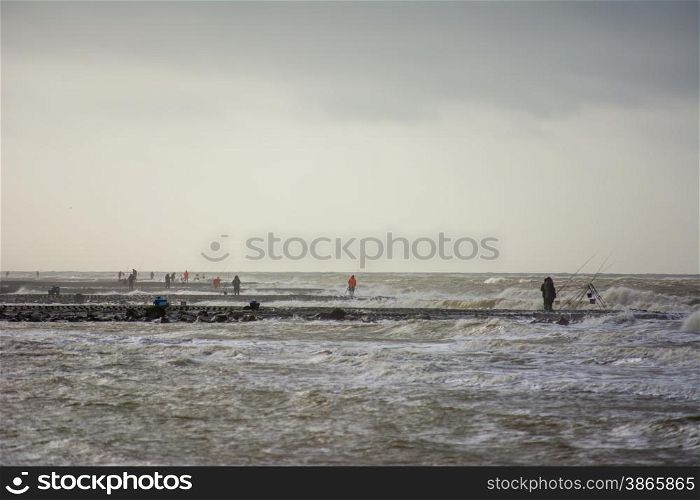 fishermen on breakwater pier in the winter